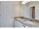 Bathroom featuring double sinks, granite countertop, and multiple doors for privacy at 775 Hales Trace Sw Way, Lilburn, GA 30047