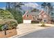 Lovely brick home featuring a manicured lawn, two-car garage and extended driveway at 775 Hales Trace Sw Way, Lilburn, GA 30047