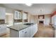 Stylish kitchen with island cooktop, granite counters, white cabinets, and fireplace view at 775 Hales Trace Sw Way, Lilburn, GA 30047