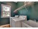 Functional laundry room with washer, dryer, sink, and storage shelf at 775 Hales Trace Sw Way, Lilburn, GA 30047