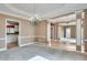 Spacious living room with hardwood floors, natural light, and decorative chandelier at 775 Hales Trace Sw Way, Lilburn, GA 30047