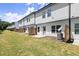 View of townhome backyards with green grass, small fences, concrete patios and white siding at 1409 Ben Park Way, Grayson, GA 30017