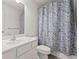 Bright bathroom featuring a vanity with a white sink, toilet, and a shower with a patterned curtain at 1409 Ben Park Way, Grayson, GA 30017