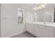 Bright bathroom with a double sink vanity, large mirror, and a window at 1409 Ben Park Way, Grayson, GA 30017