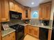 Traditional kitchen featuring granite countertops, natural wood cabinets, and modern appliances at 5400 Roswell Rd # K1, Atlanta, GA 30342