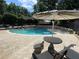 Inviting community pool with poolside seating, lounge chairs, and nearby shady umbrella at 5400 Roswell Rd # K1, Atlanta, GA 30342