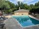 Overhead view of the sparkling community pool and brick pool house with deck chairs nearby at 5400 Roswell Rd # K1, Atlanta, GA 30342