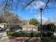 Community pool with black fence and hedges, surrounded by trees and buildings, under a blue sky at 5400 Roswell Rd # K1, Atlanta, GA 30342