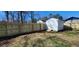 A fenced-in backyard featuring a shed with a ramp in a partially grassy and bare dirt area at 1390 White Oak St Se, Conyers, GA 30013