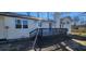 Back exterior of a white brick home featuring a deck and manicured landscaping at 1390 White Oak St Se, Conyers, GA 30013