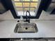 Modern kitchen sink with black faucet set against bright window and countertops at 1390 White Oak St Se, Conyers, GA 30013