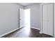 Neutral bedroom showcases an open doorway and built-in closet space complemented by dark wood-look flooring and minimalist decor at 1820 Spring St, Conyers, GA 30012