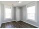 Bright bedroom with two windows, closet, and dark wood floors offers a cozy and modern space for relaxation at 1820 Spring St, Conyers, GA 30012