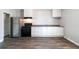 Modern kitchen boasting stainless steel refrigerator and stove, complemented by ample white cabinetry and dark wood floors at 1820 Spring St, Conyers, GA 30012