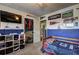 Cozy bedroom featuring blue accent walls, shelving, television, closet, and sports-themed decor at 2924 Vogue Dr, Douglasville, GA 30134