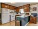 Functional kitchen with wood cabinetry, white appliances, and a peninsula for convenient meal prep at 2924 Vogue Dr, Douglasville, GA 30134