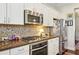 Modern kitchen features stainless steel appliances, granite countertops, and decorative mosaic tile backsplash at 327 Alderwood Ln, Atlanta, GA 30328