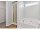 This bathroom has a tub, a shower with gold door, and new hardwood style floors at 4284 Hathaway Nw Ct, Kennesaw, GA 30144