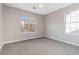 This bedroom features plush gray carpeting, two windows letting in natural light, and neutral paint tones at 4284 Hathaway Nw Ct, Kennesaw, GA 30144