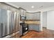 This modern kitchen has stainless steel appliances, gray cabinets and hardwood floors at 448 Cape Ivey Dr, Dacula, GA 30019