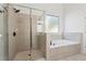 Modern main bathroom featuring a frameless shower and luxurious soaking tub at 448 Cape Ivey Dr, Dacula, GA 30019