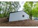 Back of home showing siding, roofline, window, and large backyard space with mature trees at 1995 Northerly Way, Stone Mountain, GA 30088