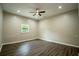 Well-lit bedroom with light wood floors, ceiling fan, and a bright window overlooking a green landscape at 1995 Northerly Way, Stone Mountain, GA 30088