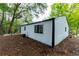 Back of home featuring siding, black trim and large windows surrounded by mature trees at 1995 Northerly Way, Stone Mountain, GA 30088