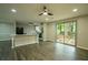 Open-concept living space with new laminate flooring, ceiling fan, and sliding glass doors to backyard at 1995 Northerly Way, Stone Mountain, GA 30088