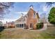 Backyard view featuring a screened porch and a well-maintained lawn with mature trees at 2760 Sugarloaf Club Dr, Duluth, GA 30097