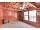 Comfortable living room with wood-paneled walls, a ceiling fan, and an electric fireplace at 2762 Zingara Ne Rd, Conyers, GA 30012