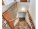 View of carpeted stairs leading to the basement with brick accent wall and handrail at 2762 Zingara Ne Rd, Conyers, GA 30012