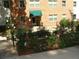 Brick building entrance with a green awning surrounded by a beautiful flower garden at 2965 Pharr Court South Nw # 110, Atlanta, GA 30305