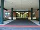 Covered front entrance to the apartment building with glass doors, green pillars, and tiled floor at 2965 Pharr Court South Nw # 110, Atlanta, GA 30305