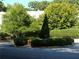 Circular landscaped traffic island with pruned shrubbery and manicured conical evergreen at 2965 Pharr Court South Nw # 110, Atlanta, GA 30305