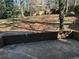 Backyard area with a concrete brick wall and an open view to nature and shade at 4502 Cherie Glen Trl, Stone Mountain, GA 30083