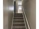 Carpeted staircase leading to the upper level with white railing and neutral walls at 4502 Cherie Glen Trl, Stone Mountain, GA 30083