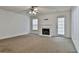 Spacious living room featuring neutral carpet, a ceiling fan, and a fireplace at 4607 Ravenwood Loop, Union City, GA 30291