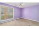 Bedroom with purple walls and carpet with a ceiling fan and one large window at 11941 Fairway Overlook, Fayetteville, GA 30215
