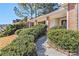 Home's entryway featuring brick accents, a covered porch, and lush landscaping at 11941 Fairway Overlook, Fayetteville, GA 30215