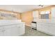 Bright kitchen features white cabinets, white countertops, tile floors, and stainless appliances at 11941 Fairway Overlook, Fayetteville, GA 30215