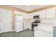 Efficient kitchen with white cabinets, tile floors, and modern appliances at 11941 Fairway Overlook, Fayetteville, GA 30215