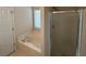 Bright bathroom featuring a soaking tub and separate shower with glass door at 684 Beranda Cir, Douglasville, GA 30134