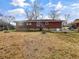 Backyard showcasing a single-story brick house with a dry grass lawn and tree stumps at 1742 Mural Dr, Morrow, GA 30260