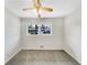 Cozy bedroom with neutral-toned walls and carpet, featuring a bright window and a ceiling fan at 1742 Mural Dr, Morrow, GA 30260