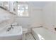 Bathroom featuring a sink, mirror, toilet, and bathtub with white wall tiles at 3951 Lindley Dr, Powder Springs, GA 30127