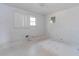 Bedroom featuring white walls, white floors, a window, and light fixture at 3951 Lindley Dr, Powder Springs, GA 30127