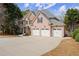 Charming two-story home with a three-car garage and a large driveway, set amidst lush greenery at 403 Mill Xing, Canton, GA 30114