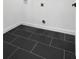 This is an image of a laundry room with black tile floors, and white walls at 907 Oakhill Sw Ave, Atlanta, GA 30310