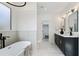 Bright bathroom showcasing a soaker tub, double vanity, modern fixtures and marble tiling at 907 Oakhill Sw Ave, Atlanta, GA 30310